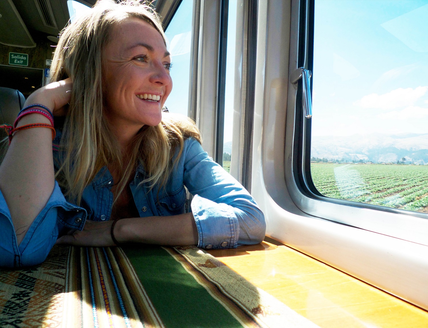 Kira Goodwin smiles while looking out to a field from a train window