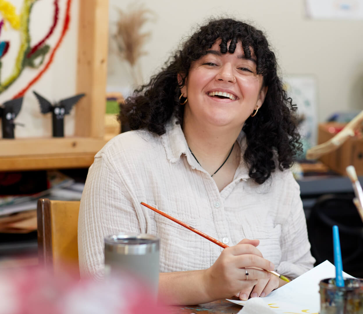 A woman smiles while participating in an art class at the Victoria Native Friendship Centre.
