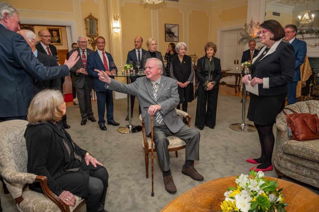 Mel Cooper speaking with various guests at his 90th birthday celebration.