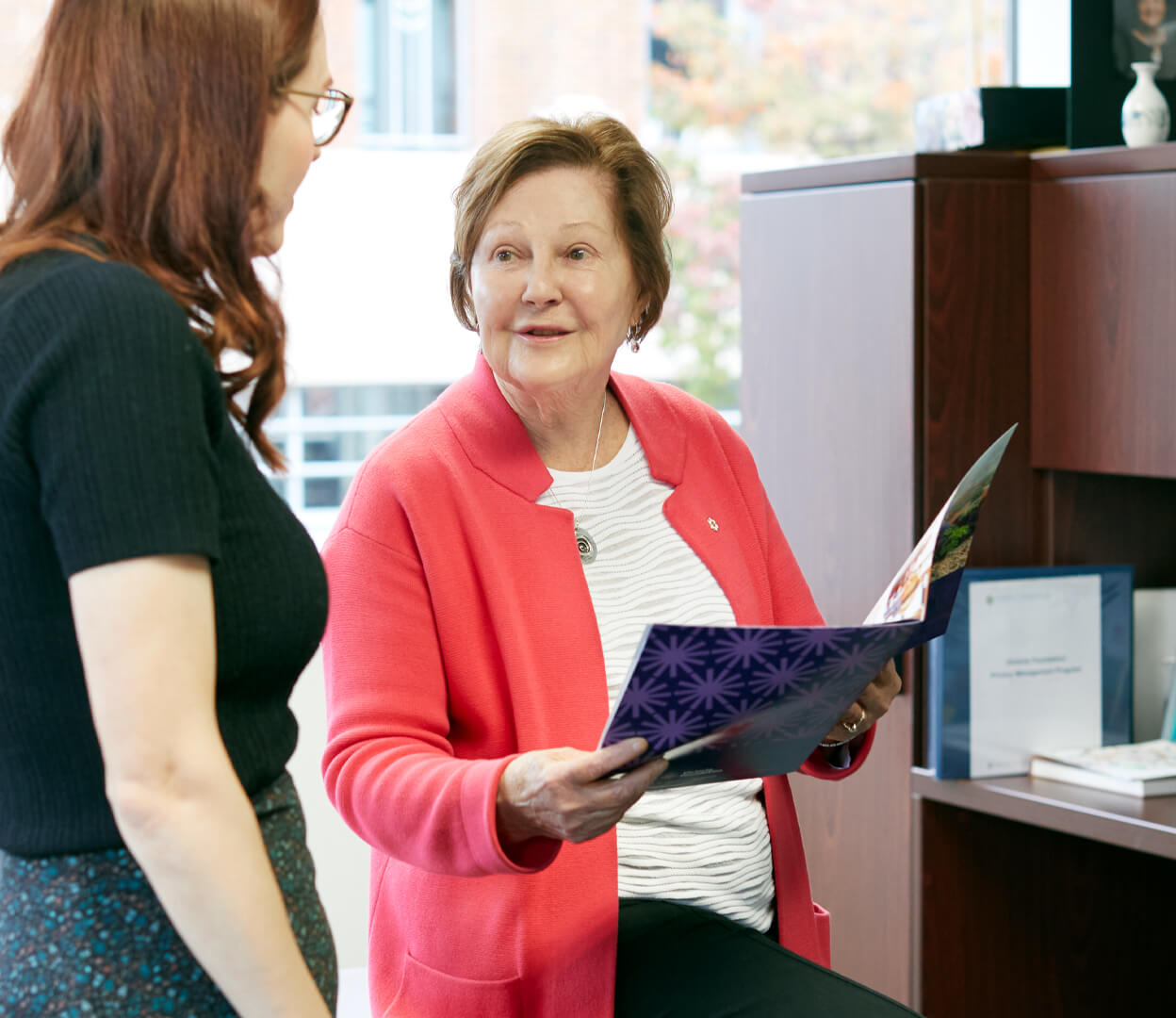 An image of Sandra Richardson having a conversation in her office with a colleague.