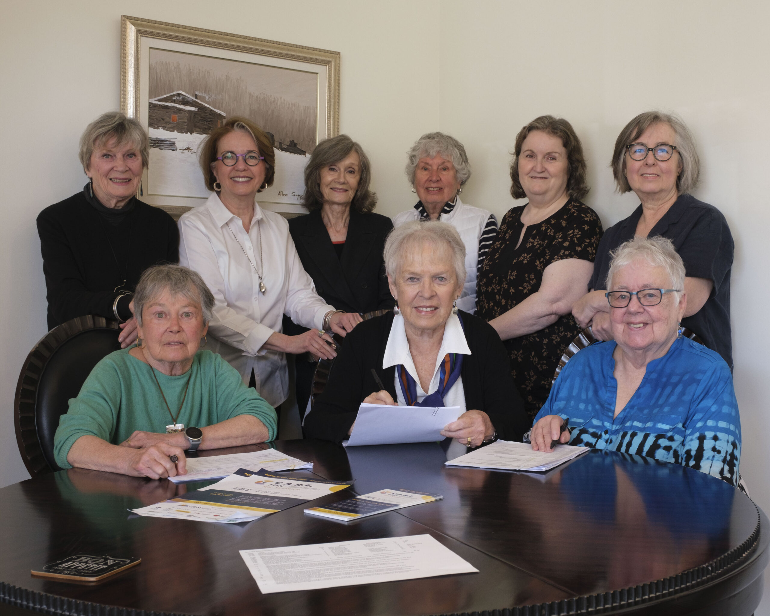 Members of CFUW Saanich Peninsula smile while sitting around a table.