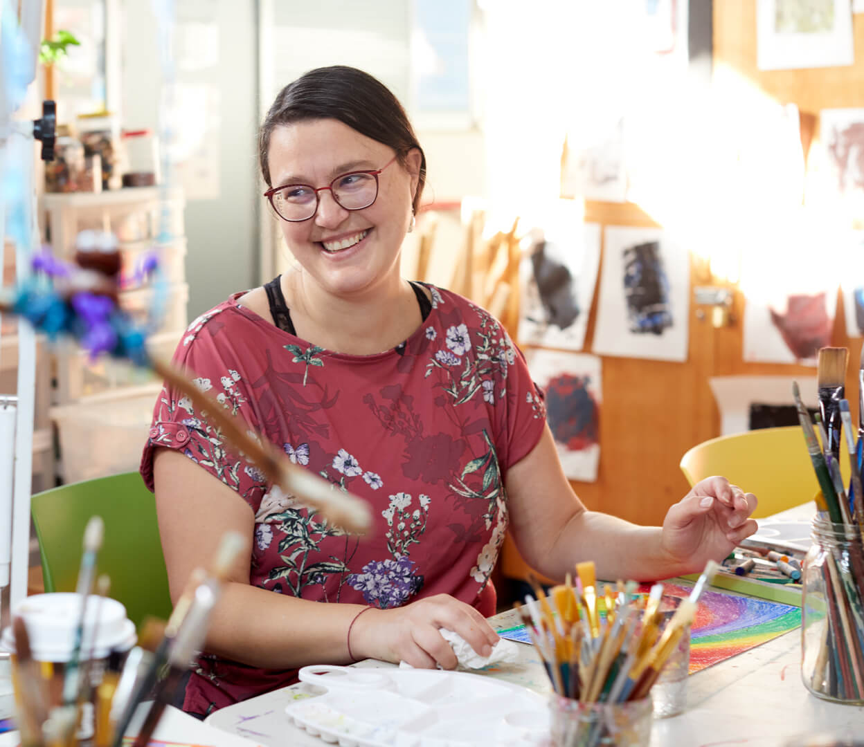 A woman smiles while participating in an art class at the Victoria Native Friendship Centre.