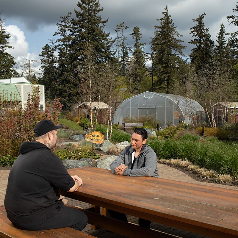 Two men sitting together at New Roads.