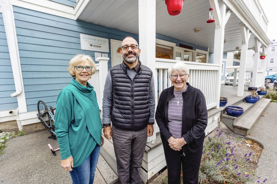 Anawim House board members pose in front of Anawim House for men.