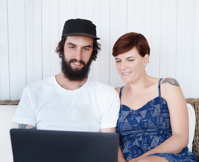A young couple use Epilogue, typing out their Will on a laptop together.