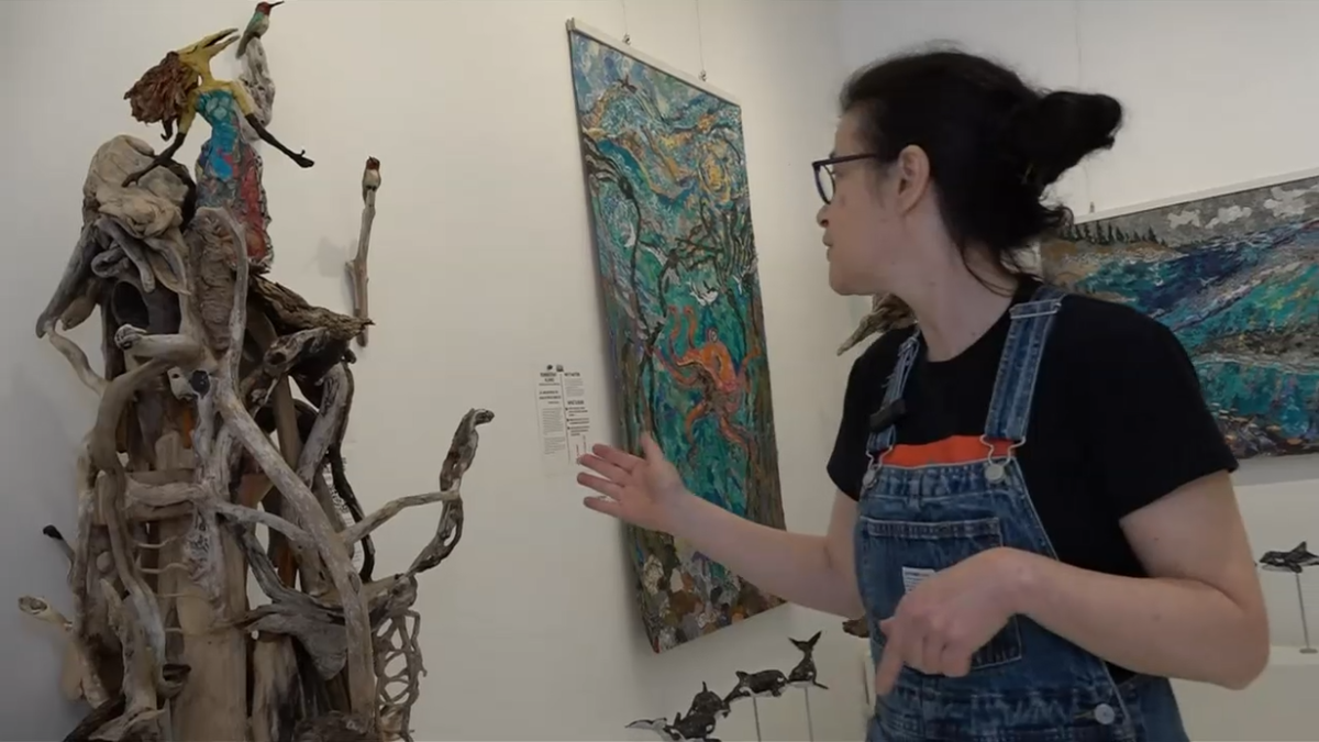 Artist Tanya Bub describes one of her driftwood scultures at the Gage Gallery.
