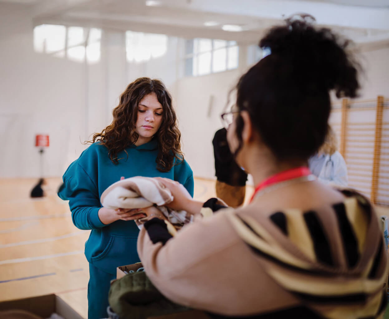 Women distributing and receiving assistance in a gymnasium
