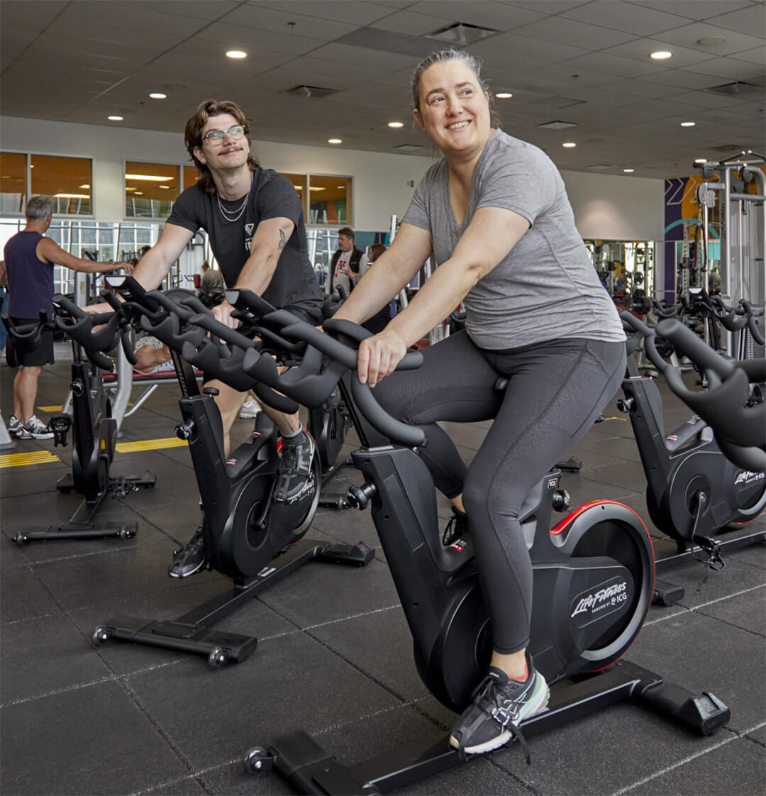 Gym-goers ride stationary bikes